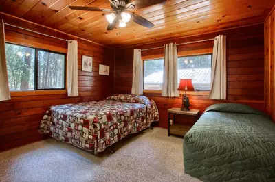 a bedroom with two beds and a ceiling fan at Deer Creek in Wawona