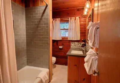 a bathroom with a tub and a toilet and a sink at The Williams Cabin in Wawona