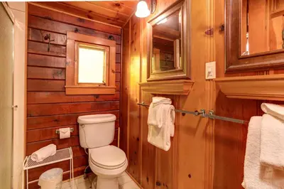 a bathroom with a toilet and wooden walls at Hansen Cabin in Wawona
