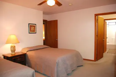 a bedroom with two beds and a ceiling fan at Edmond's Place in Wawona