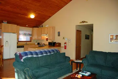 a living room with two couches and a kitchen at Edmond's Place in Wawona