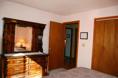 a bedroom with a wooden dresser and a mirror at Edmond's Place in Wawona