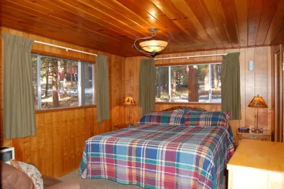 a bedroom with a bed in a wooden cabin at Squirrel's Nest in Wawona