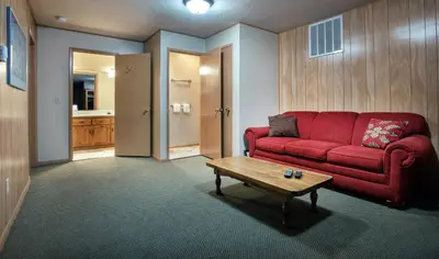 a living room with a red couch and a coffee table at River Lodge in Wawona