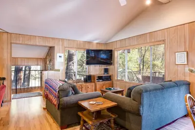 a living room with two couches and a tv at River Lodge in Wawona
