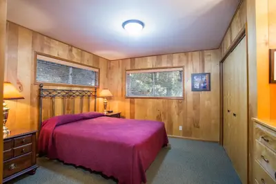 a bedroom with a bed and wooden walls at River Lodge in Wawona