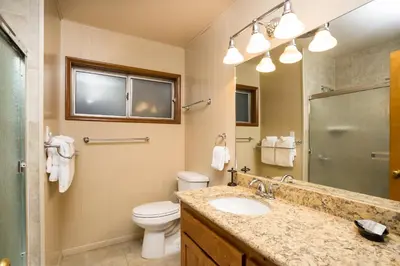 a bathroom with a sink and a toilet and a mirror at River Lodge in Wawona