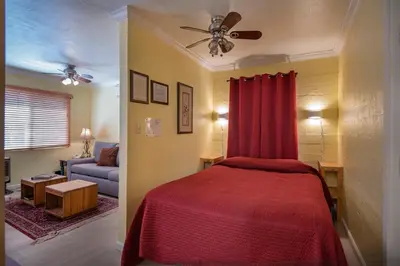 a bedroom with a red bed and a couch at Sparrow's Nest in Wawona