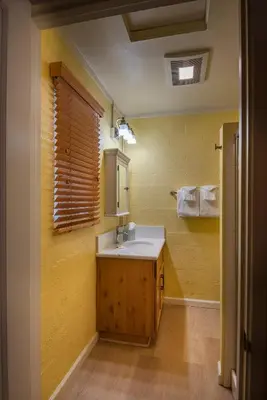 a bathroom with a sink and a yellow wall at Sparrow's Nest in Wawona