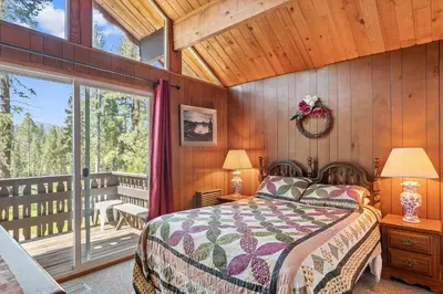 a bedroom with a bed and a balcony at Meadow View in Wawona
