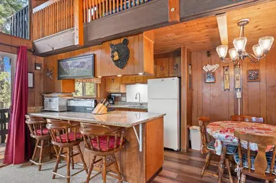 a kitchen with a counter and a refrigerator and a table at Meadow View in Wawona