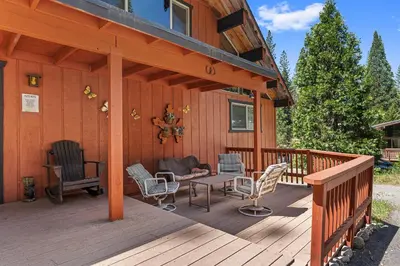 a large wooden deck with chairs and a table at Meadow View in Wawona