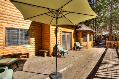 a large yellow umbrella sitting on a wooden deck at Cedar Lodge in Wawona