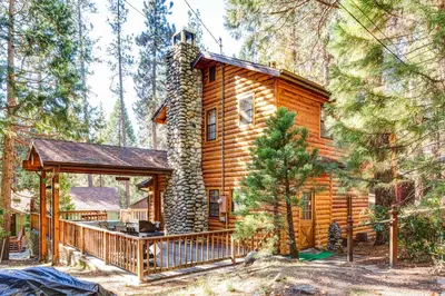 a cabin in the woods with a deck and a gazebo at Cedar Lodge in Wawona