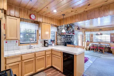 a kitchen with wooden cabinets and a dining room at Cedar Lodge in Wawona