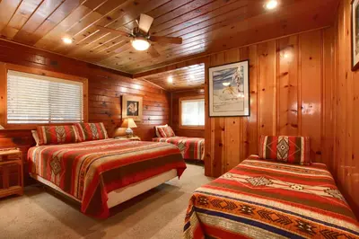 a bedroom with two beds and a ceiling fan at Simmons Den in Wawona