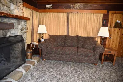 a living room with a couch and a fireplace at Sequoia in Wawona