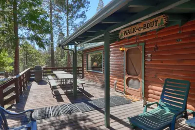 a cabin with two chairs and a table on a deck at Walk-A-Bout in Wawona