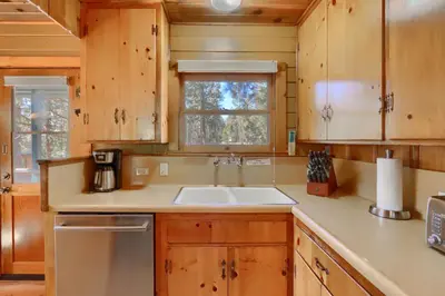 a kitchen with wooden cabinets and a sink and a window at Walk-A-Bout in Wawona