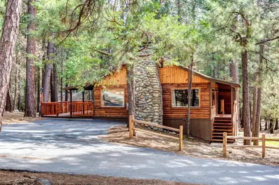 a log cabin in the middle of a forest at Our Yosemite Getaway in Wawona
