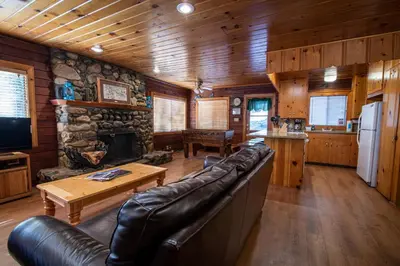 a living room with a leather couch and a fireplace at Howard's Retreat in Wawona
