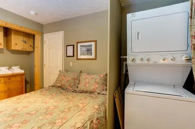 a small bedroom with a bed and a washer at Wawona Chalet in Wawona