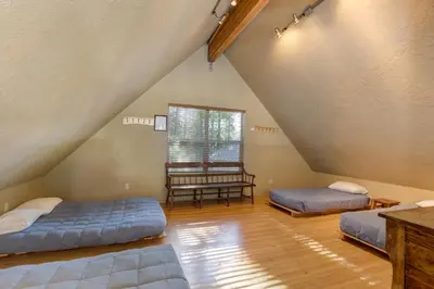 a attic bedroom with two beds and a window at Wawona Chalet in Wawona