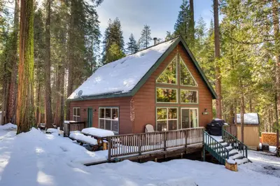 a log cabin in the woods in the snow at Wawona Chalet in Wawona