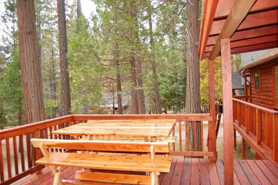 a wooden deck with benches on a cabin at Nugent's Nest in Wawona