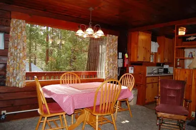 a dining room with a table and chairs and a window at Nugent's Nest in Wawona