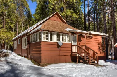 a small cabin in the snow in the woods at Chatterton's Cottage in Wawona