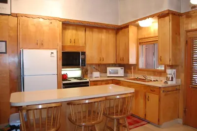 a kitchen with wooden cabinets and a white refrigerator at Shehadey's Retreat in Wawona