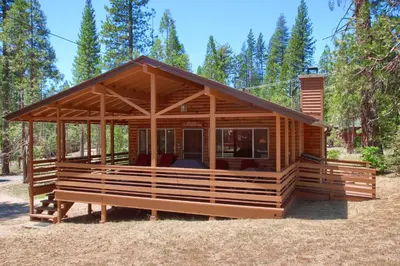 a cabin in the woods with a large roof at Hasting's Hideaway in Wawona