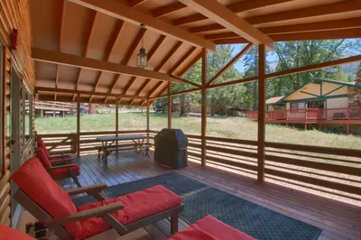 a screened in porch with chairs and a table at Hasting's Hideaway in Wawona