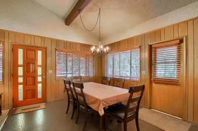 a dining room with a table and chairs and windows at Hasting's Hideaway in Wawona