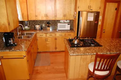 a kitchen with wooden cabinets and a stainless steel refrigerator at Harmony Villa in Wawona