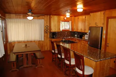 a kitchen with a counter and a island with bar stools at Harmony Villa in Wawona