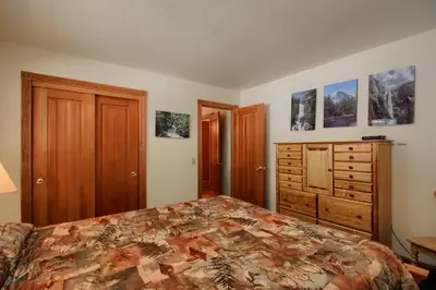 a bedroom with a bed and a dresser at Jolie Cabin in Wawona