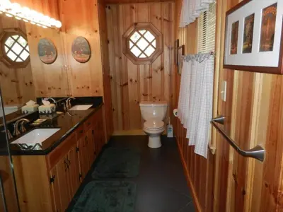 a wooden bathroom with a toilet and a sink at Deer Lodge in Wawona