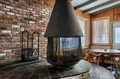a fireplace in a room with a brick wall at The Little Creek Cabin in Wawona
