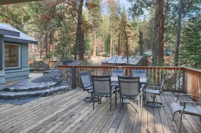 a wooden deck with a table and chairs on it at The Little Creek Cabin in Wawona