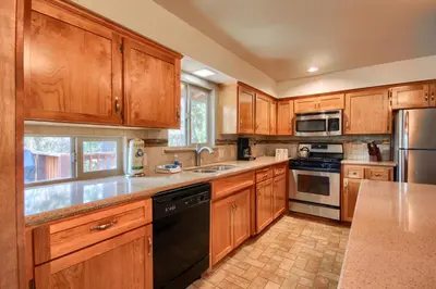 a kitchen with wooden cabinets and stainless steel appliances at Yosemite Mountain Lodge in Wawona
