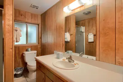 a bathroom with a sink and a toilet and a mirror at Yosemite Mountain Lodge in Wawona