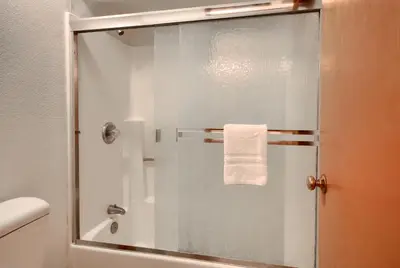 a glass shower door in a bathroom with a towel at Yosemite Mountain Lodge in Wawona