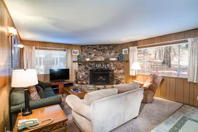 a living room with a couch and a fireplace at Deer Hollow in Wawona
