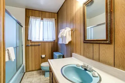 a bathroom with a sink and a toilet and a mirror at Deer Hollow in Wawona