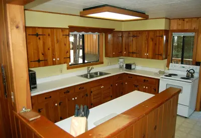 a large kitchen with wooden cabinets and a sink at Burke's Place in Wawona