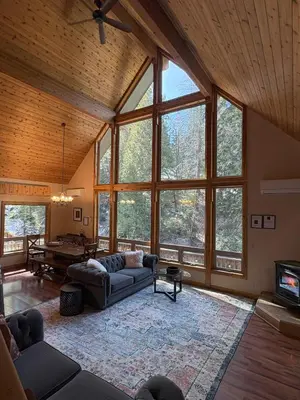a large living room with large windows and a couch at Lily of the Valley - Big Wall, Yosemite Day Use Reservations, Breakfast, Forest View and WiFi in Yosemite West