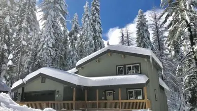 a house covered in snow in front of trees at Lily of the Valley - Big Wall, Yosemite Day Use Reservations, Breakfast, Forest View and WiFi in Yosemite West