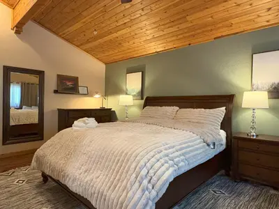 a bedroom with a large bed with a wooden ceiling at Lily of the Valley - Big Wall, Yosemite Day Use Reservations, Breakfast, Forest View and WiFi in Yosemite West